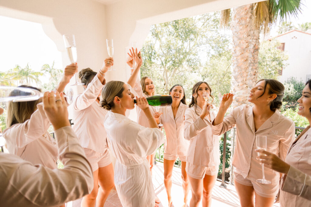 Bride and her bridesmaids celebrating with champagne