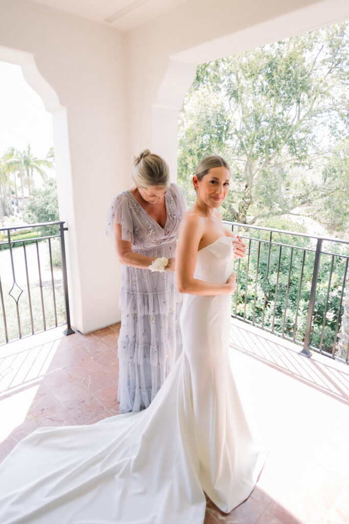 Bride and her mother put her dress on for her Bacara wedding